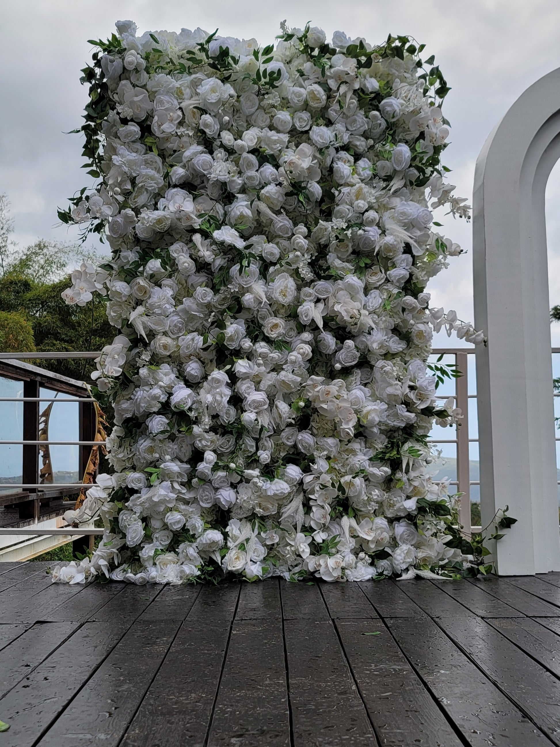 Floral wall decoration on a wooden deck with a clear sky background