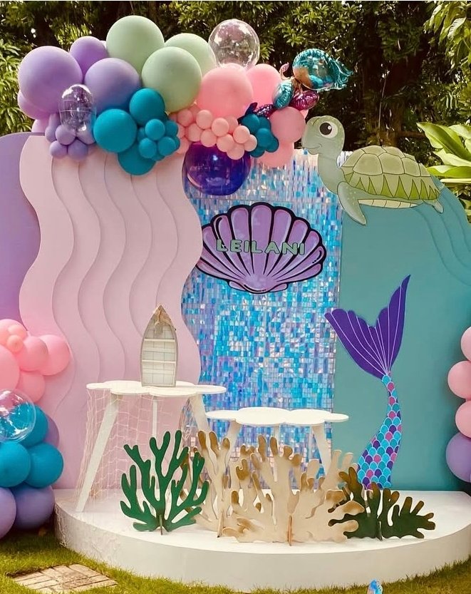 Underwater-themed birthday party setup with balloons, mermaid tail, and sea-themed decorations.